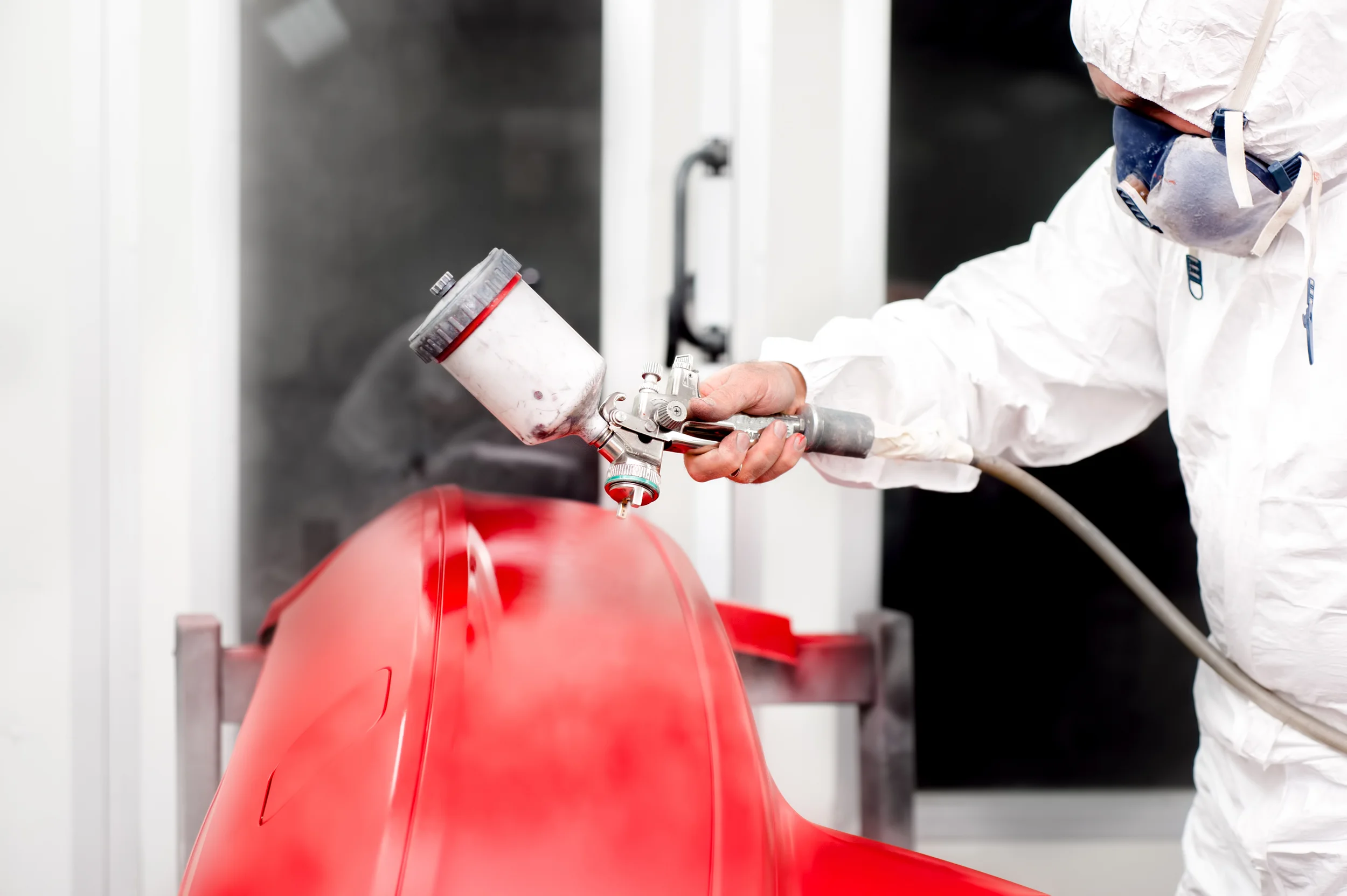 Technician refinishing a vehicle in the paint booth